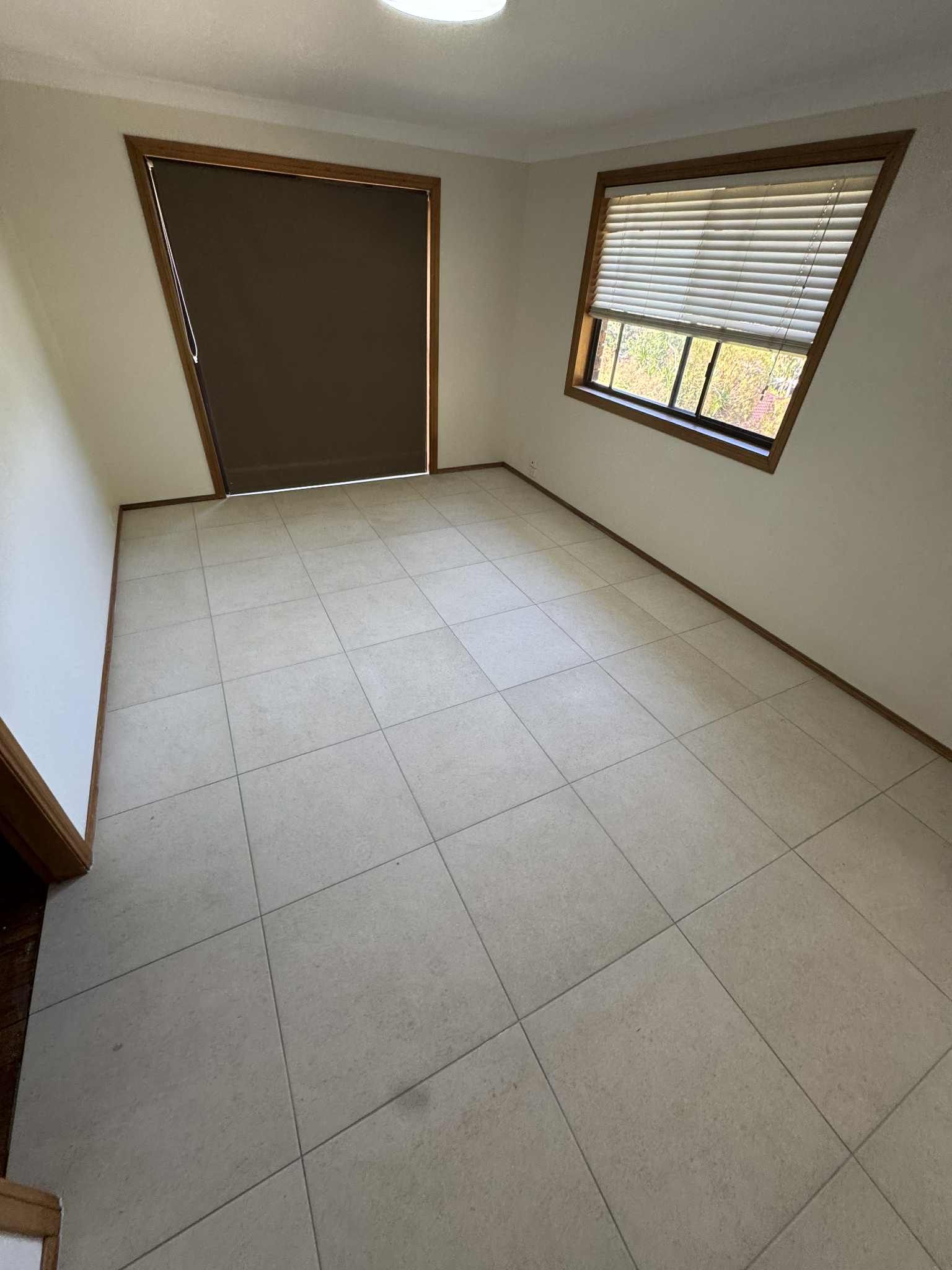 Empty Tiled Room with White Walls, a Window with Blinds — Midcoast Wall & Floor Tiling in Sapphire Beach, NSW
