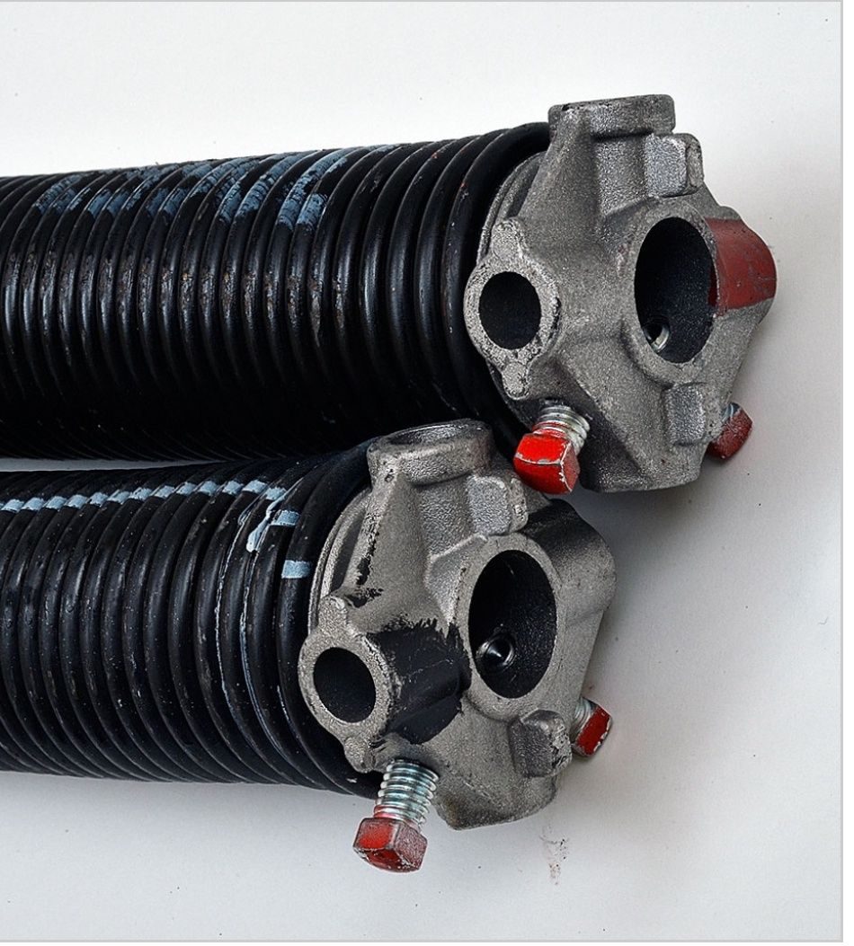 Two black corrugated hoses with metal fittings and red caps on a white background