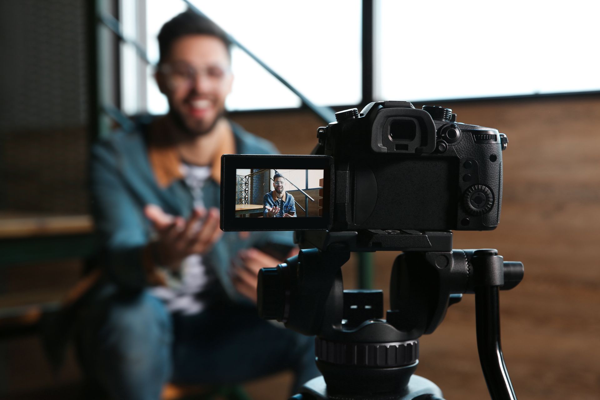 A man is sitting in front of a camera recording a video.