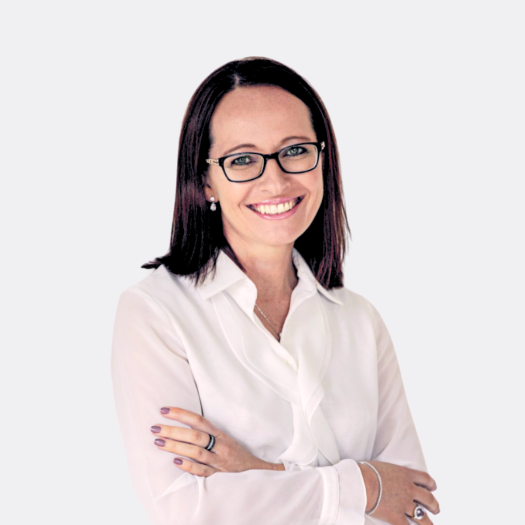 A woman wearing glasses and a white shirt is smiling with her arms crossed.