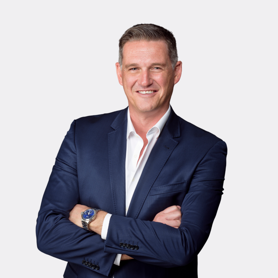 A man in a blue suit and white shirt with his arms crossed
