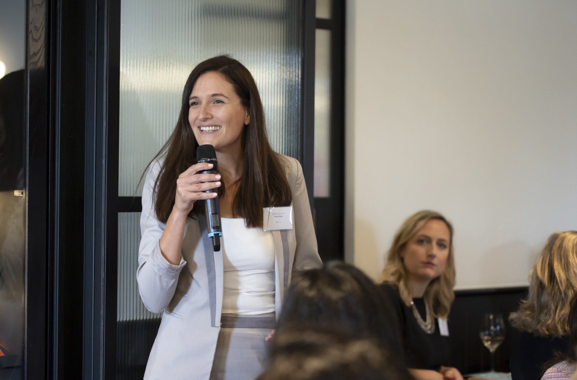 A woman is holding a microphone in front of a group of people.