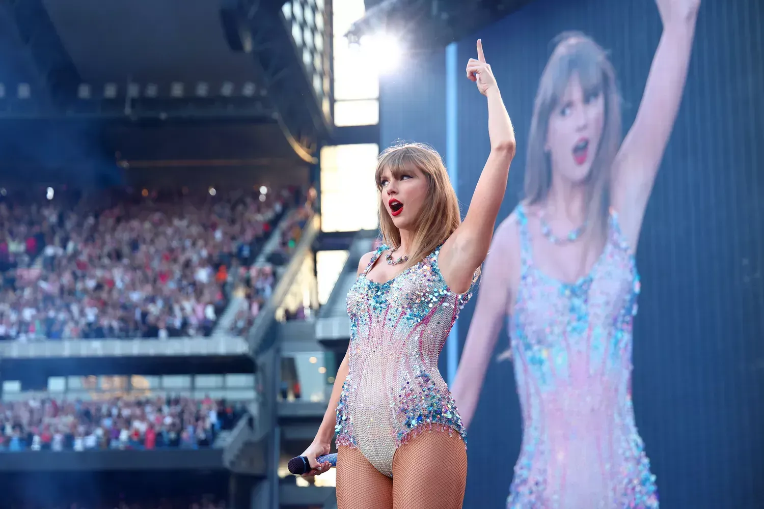 Taylor swift is performing on stage in front of a crowd.