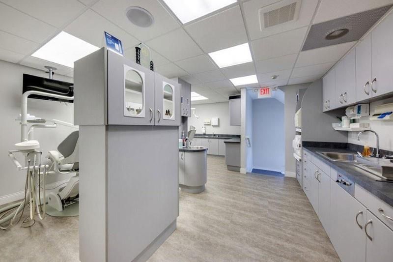A dental office with a dental chair and a sink.