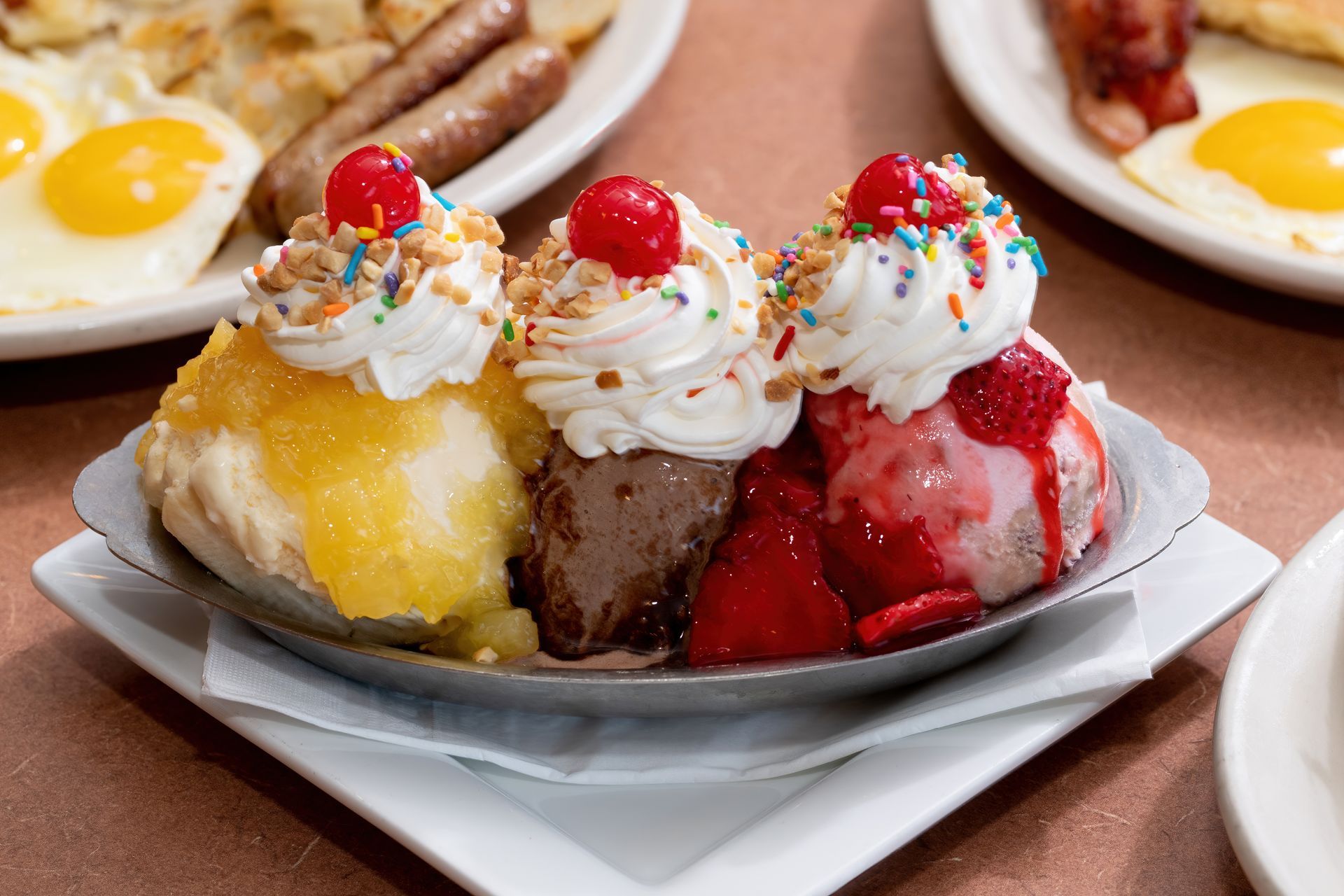 A sundae with strawberries and whipped cream on a plate