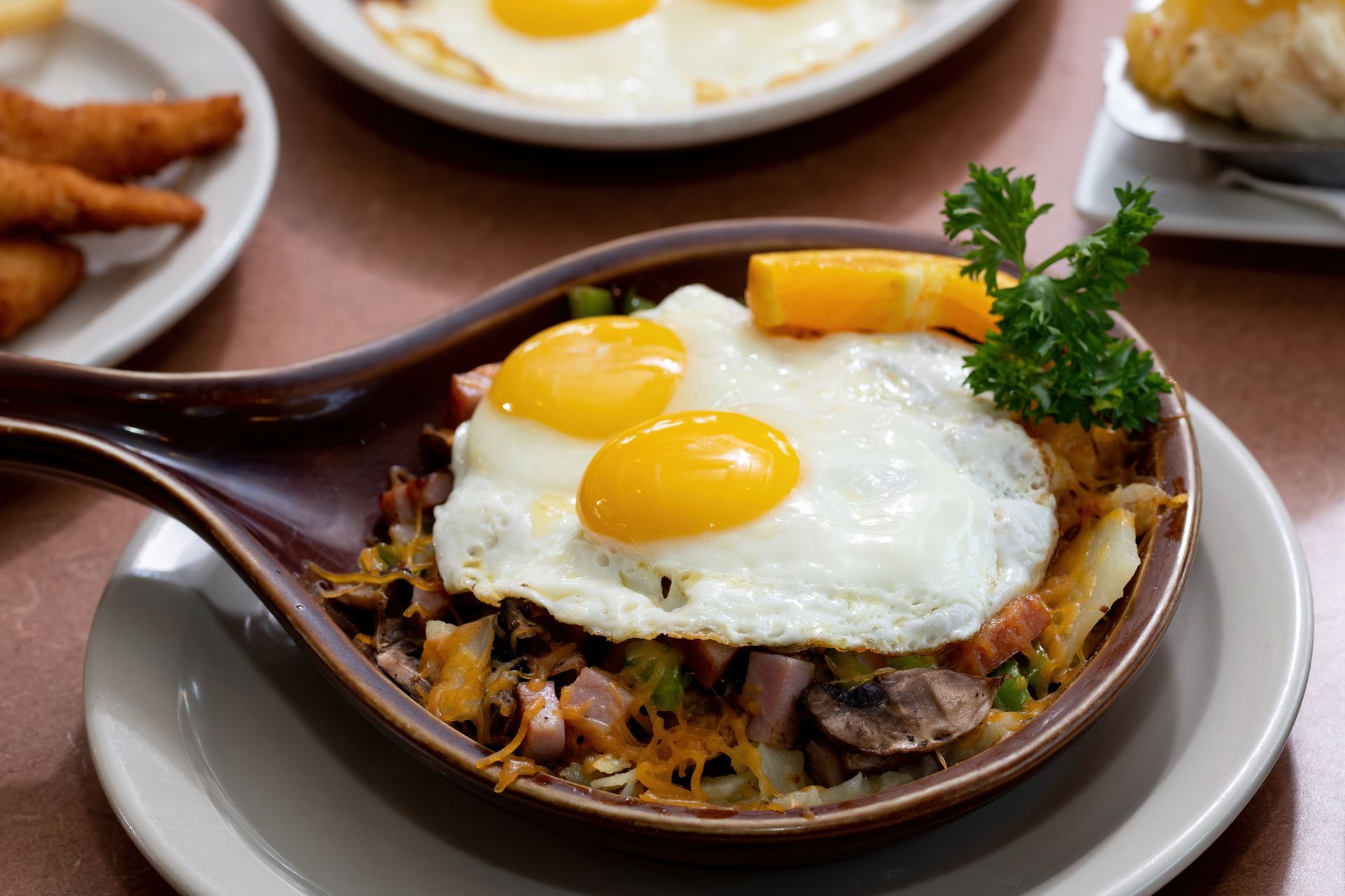 A pan filled with eggs and hash browns with a spoon in it