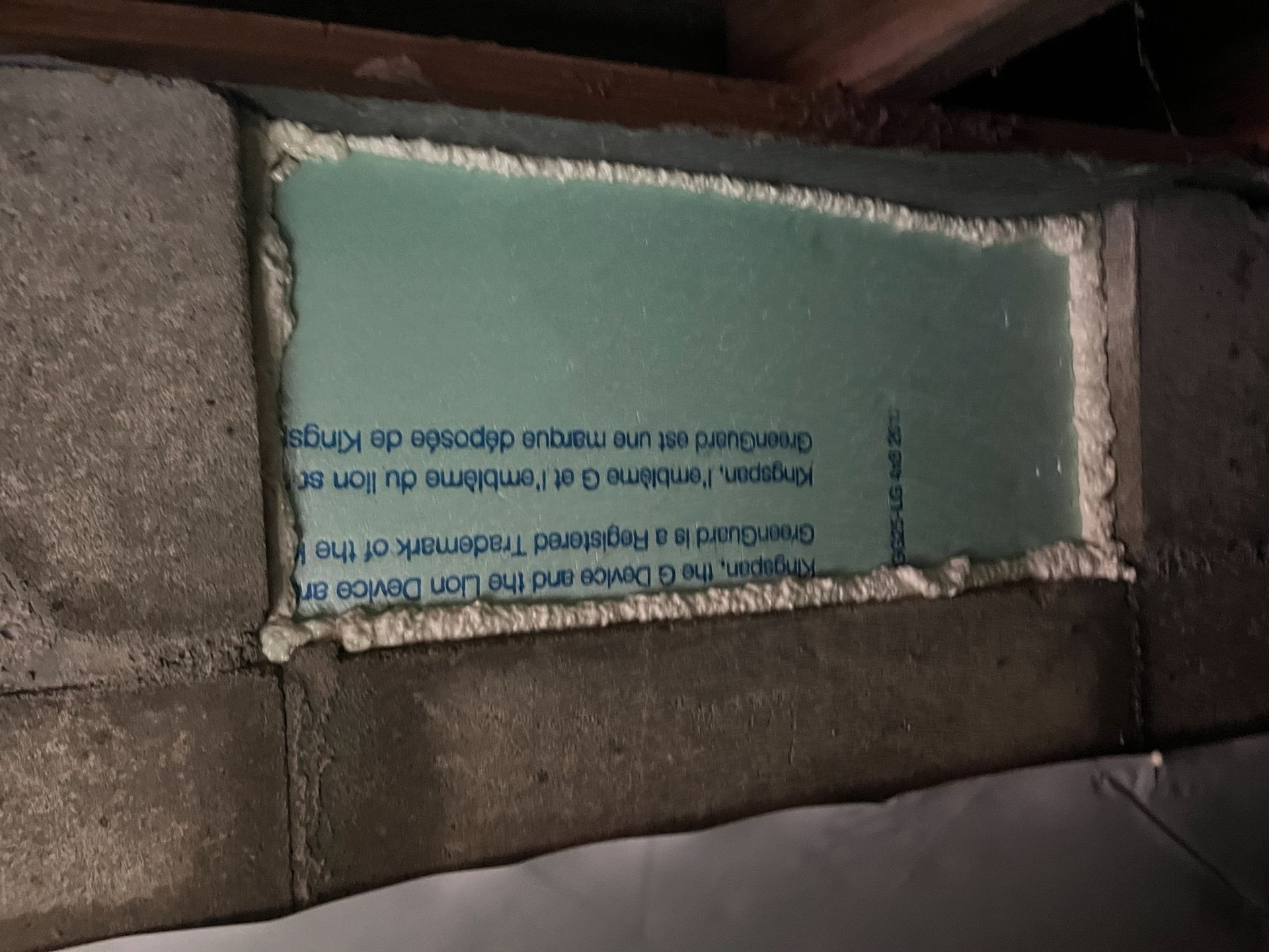 Insulation foam board exposed in a wall cavity with a brick or concrete opening.