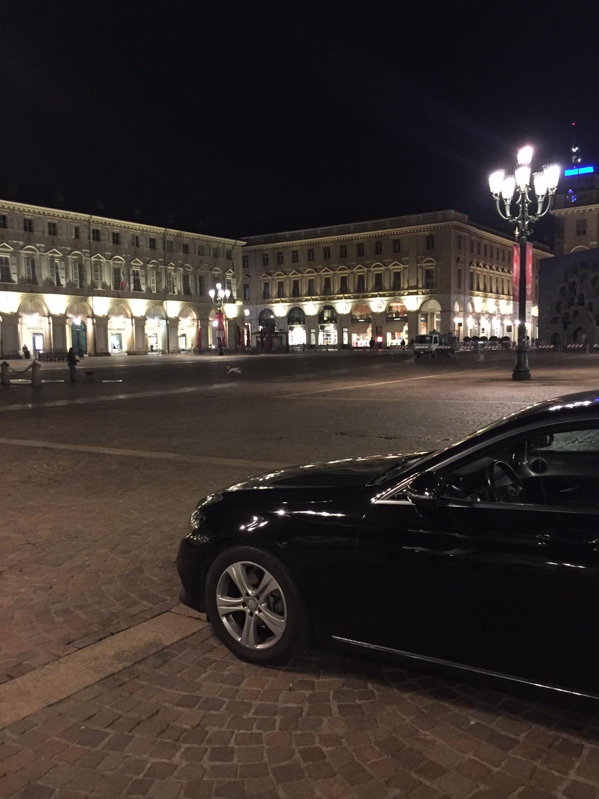 Une voiture noire est garée devant un bâtiment la nuit