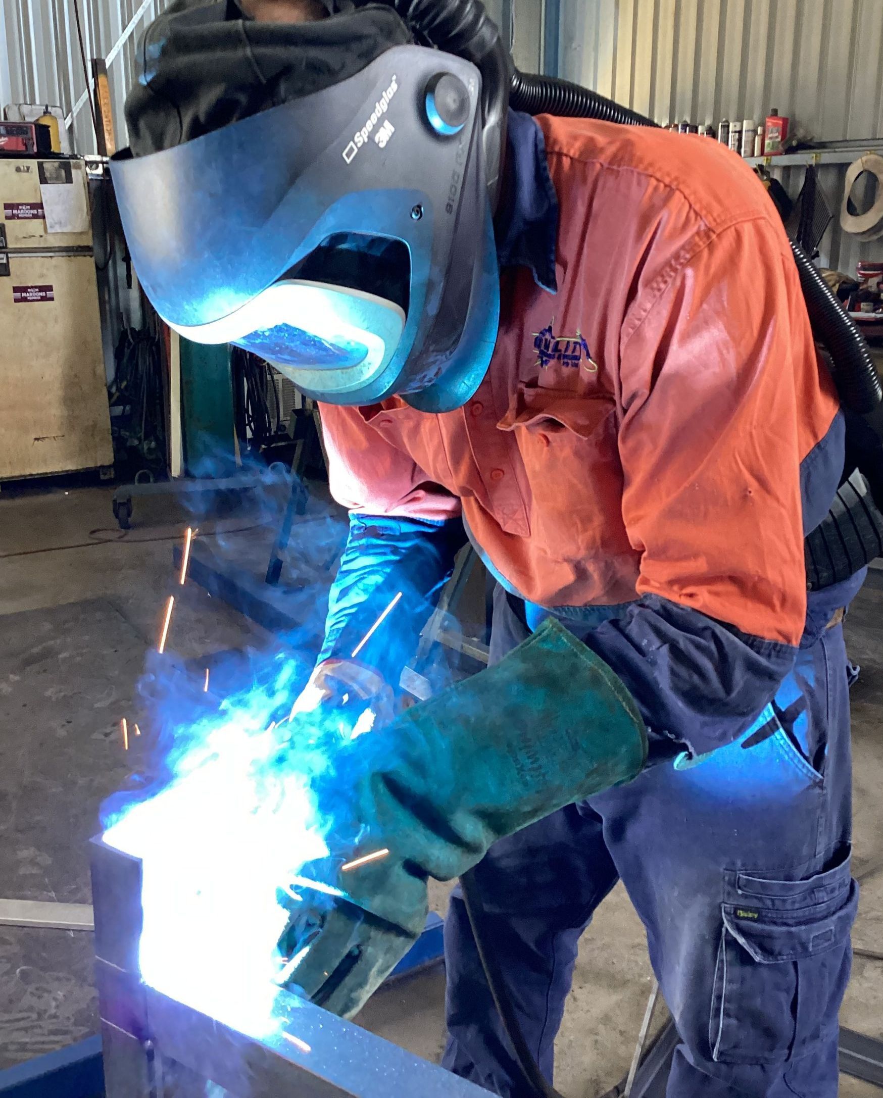 A Man Is Welding A Piece Of Metal In A Factory — Quality Fabrications & Welding Pty Ltd In Bohle, QLD
