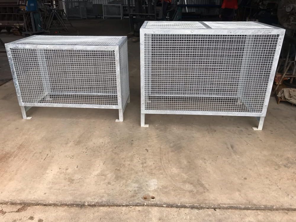 Two White Metal Crates Are Sitting Next To Each Other On The Ground — Quality Fabrications & Welding Pty Ltd In Bohle, QLD