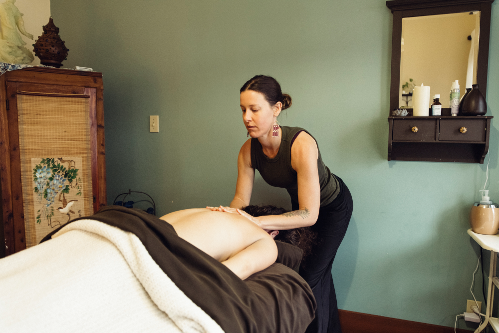 Massage therapist working on a client on a table in a calm spa room
