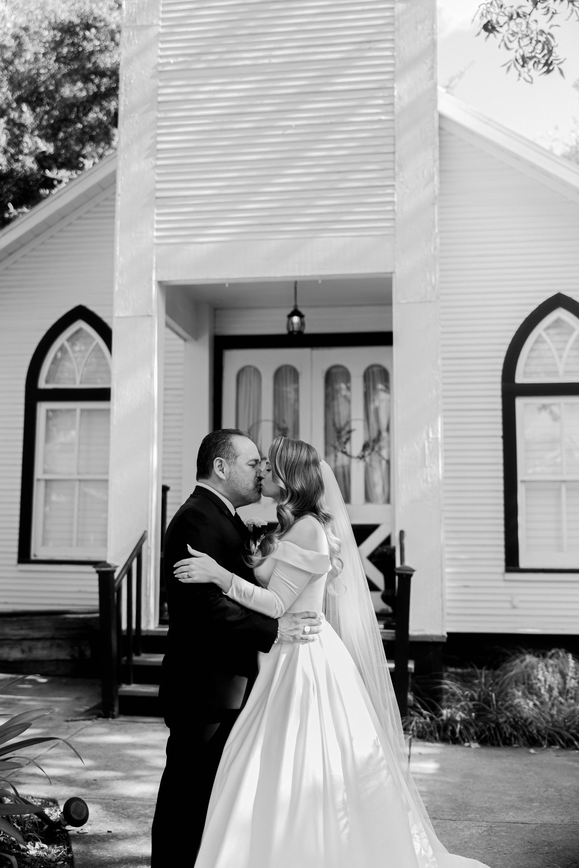 Couple embracing in front of a church entrance on their wedding day
