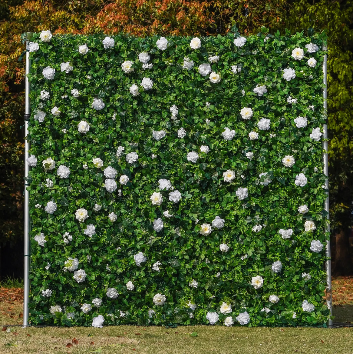 A green floral wall with scattered white flowers in a garden setting