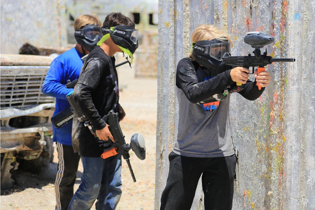 A group of people are playing paintball on a field.