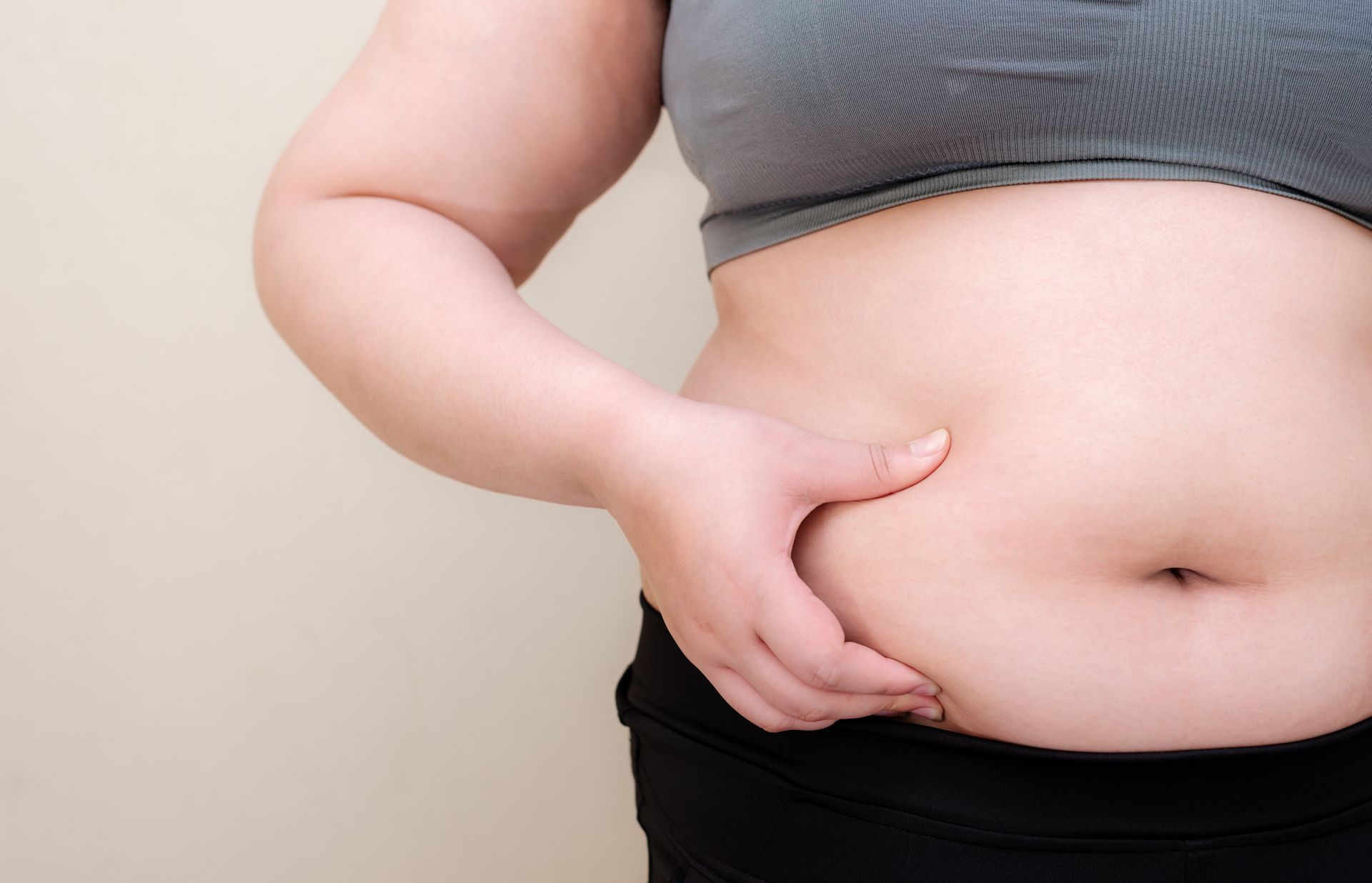 a woman pinching her belly fat