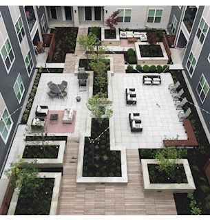 Courtyard with various seating areas, planters, trees, and gray apartment buildings.