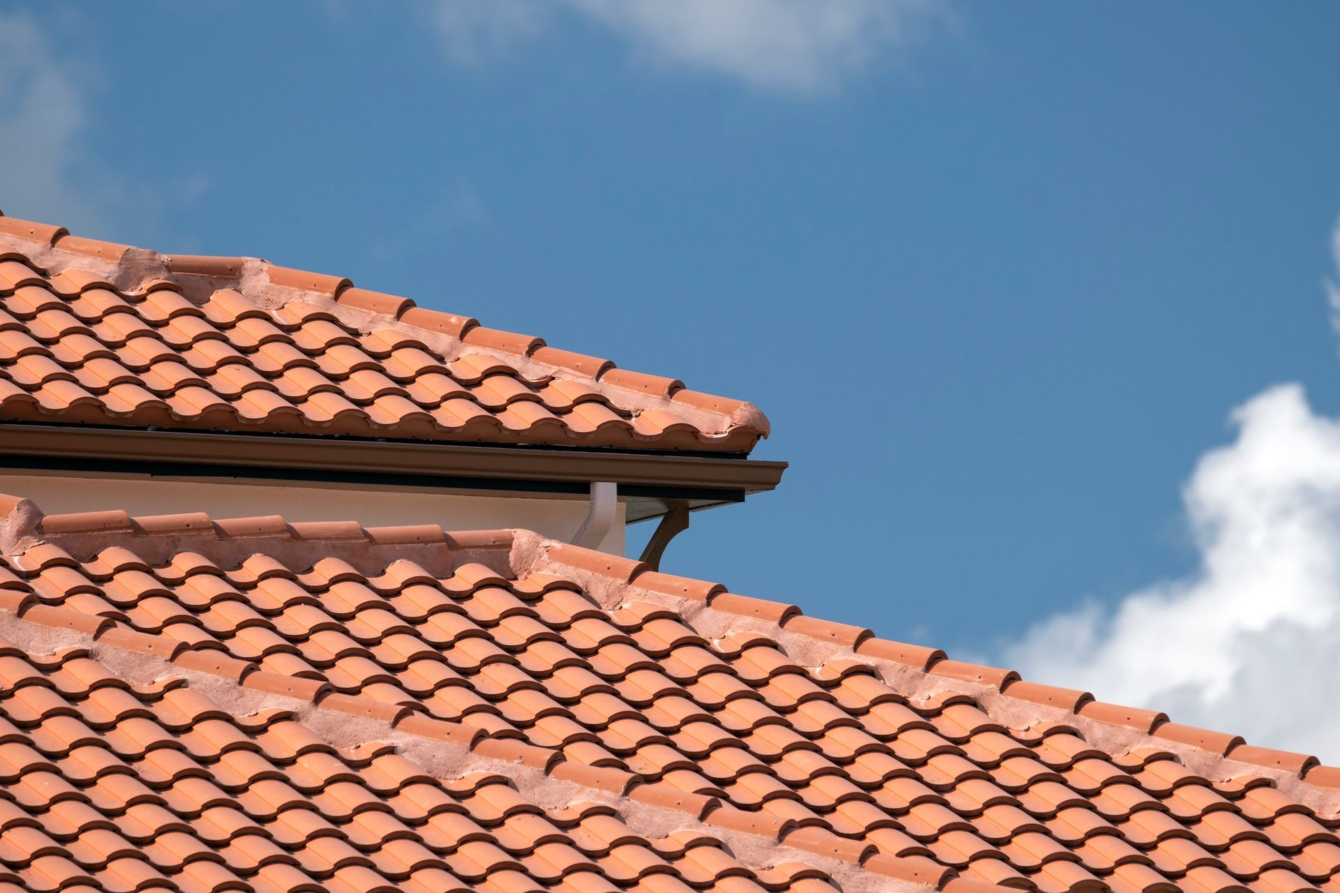 A close up of a roof with a blue sky in the background.