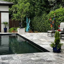 A large swimming pool surrounded by chairs and trees