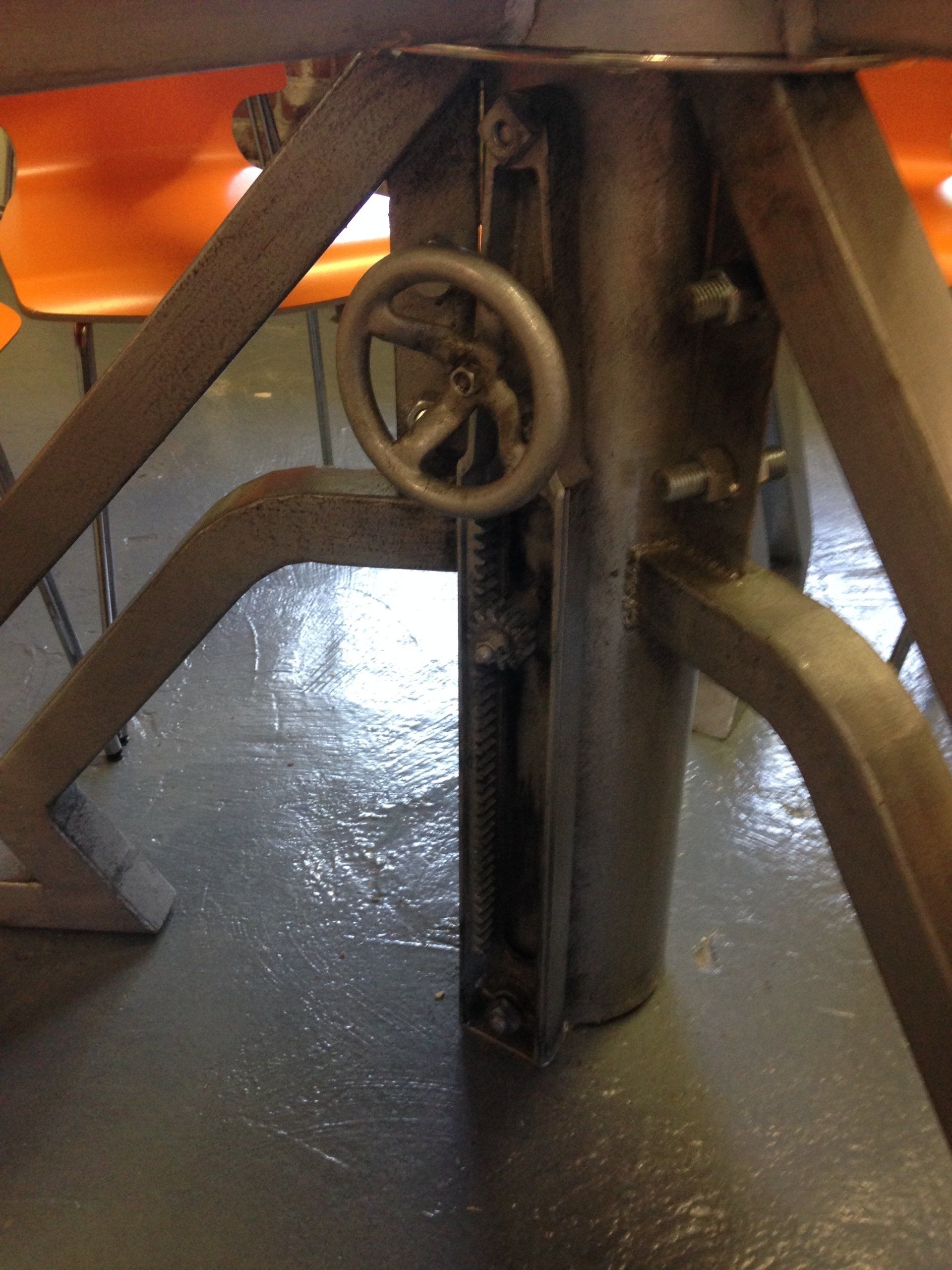 A close up of a metal object with a wheel on it