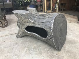 A log with a hole in the middle is sitting on the ground.