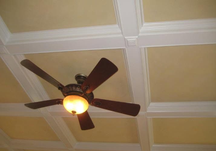 Ceiling fan with light on a beige, white-trimmed coffered ceiling