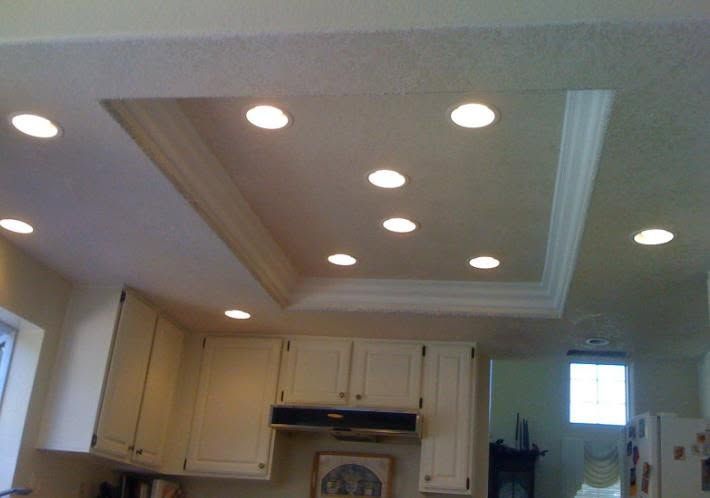 Kitchen ceiling with recessed lights and beige cabinets beneath a tray ceiling