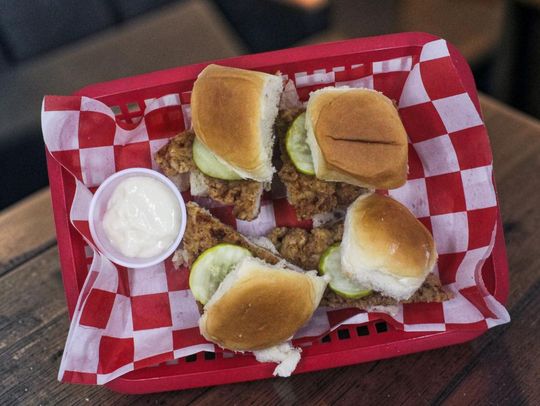Four tenderloin sliders on Hawaiian rolls and pickle.