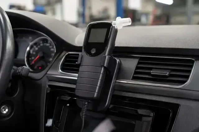 Car phone mount holding a device on a car dashboard near the air vent and steering wheel