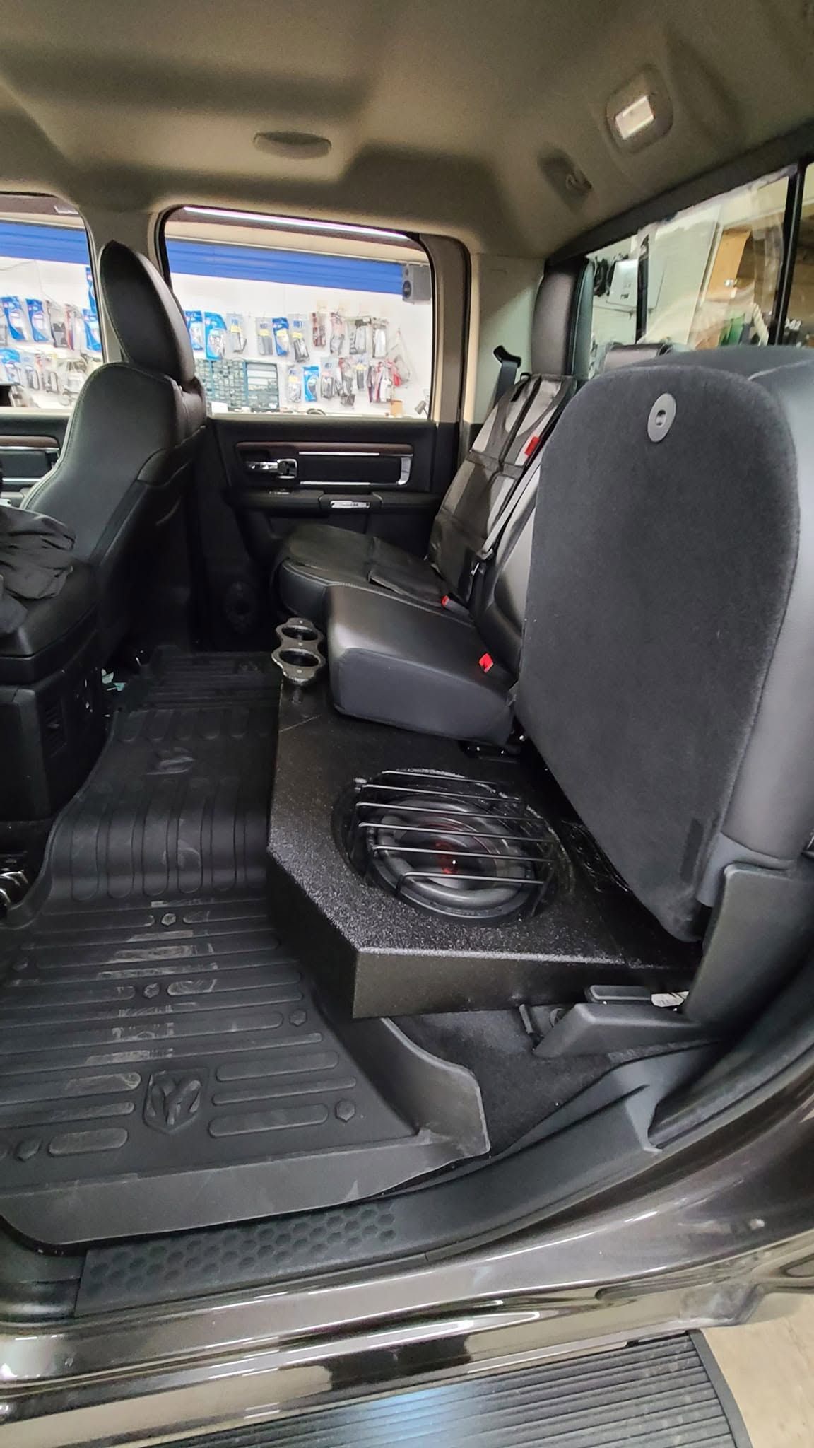 Inside a van, black leather seats and a rubber floor face forward, with the sliding door open.