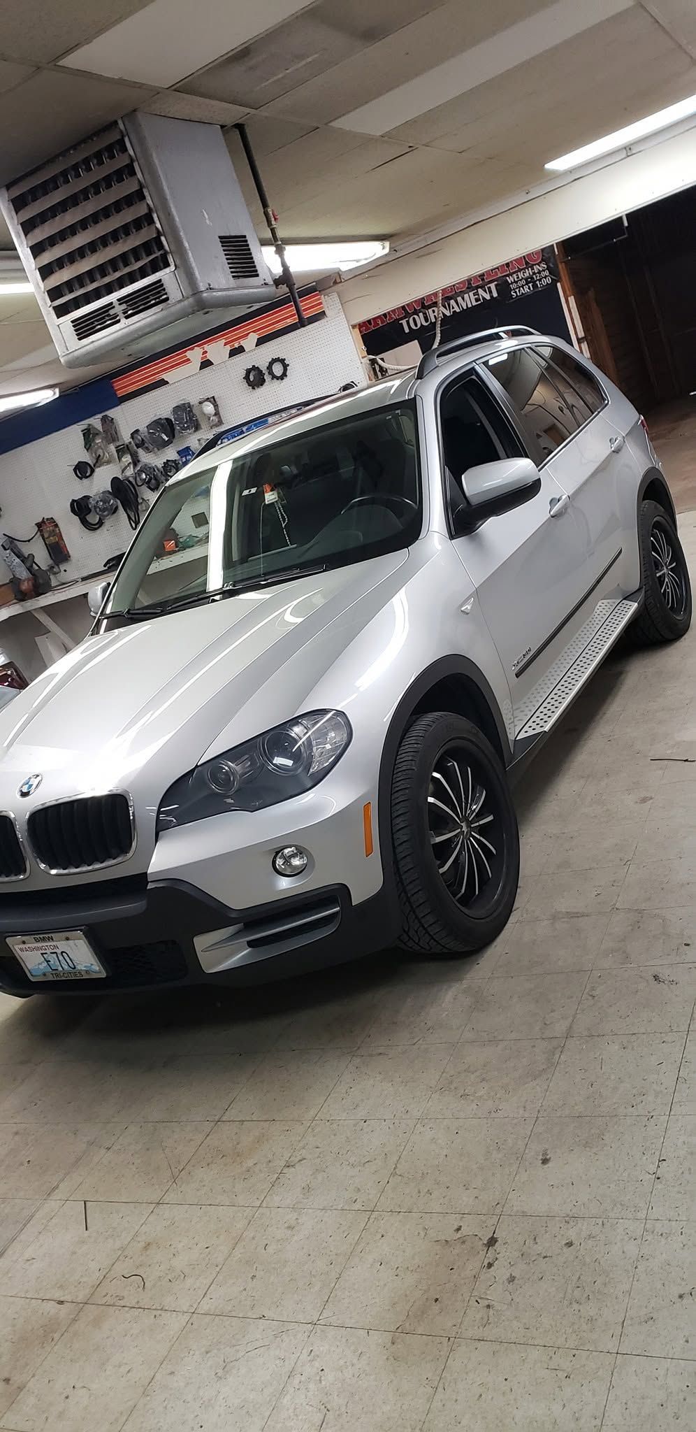 Silver SUV parked indoors in a garage, angled toward the camera.