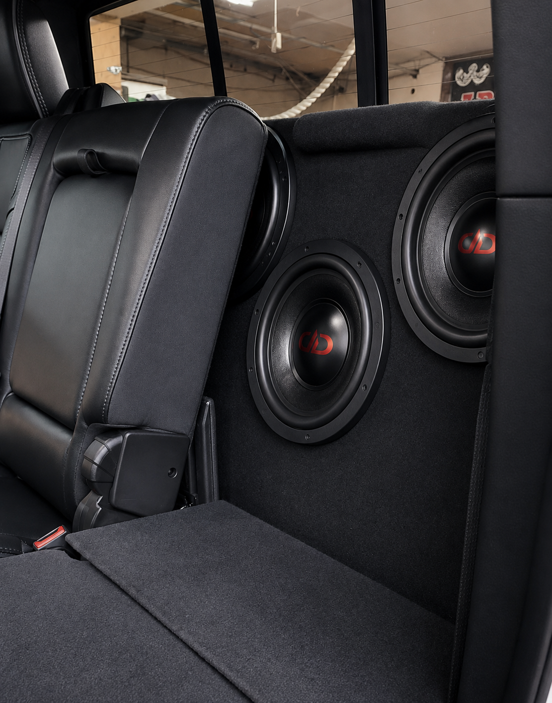 Black car interior with two subwoofers mounted behind the rear seats