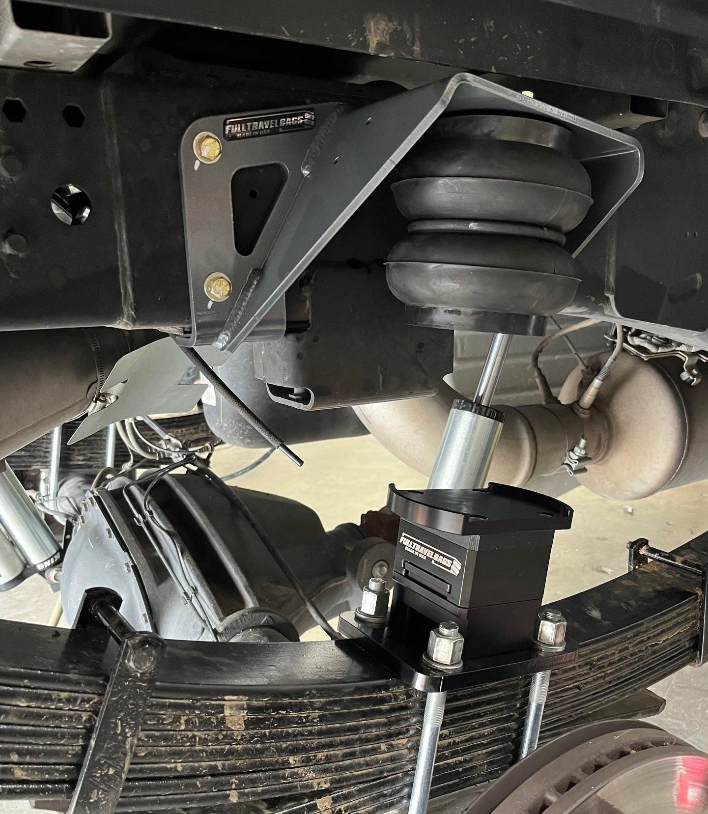 Truck suspension airbag and shock absorber above a leaf spring under the chassis