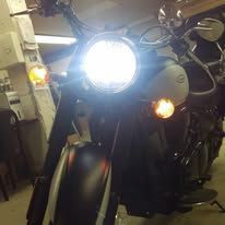 Motorcycle with bright headlight and amber turn signal in a dim garage