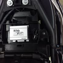 Close-up of a car battery with BOSS Powerports branding inside a vehicle compartment