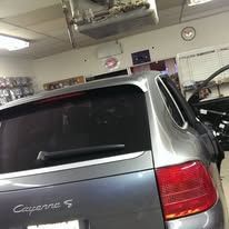 Silver Porsche Cayenne S in a garage, rear view with red taillight visible