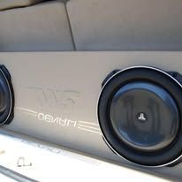 Car audio subwoofer enclosure with two round black speakers and a gray center panel