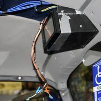 Small black device with a copper wire mounted inside a vehicle near a handicap sign
