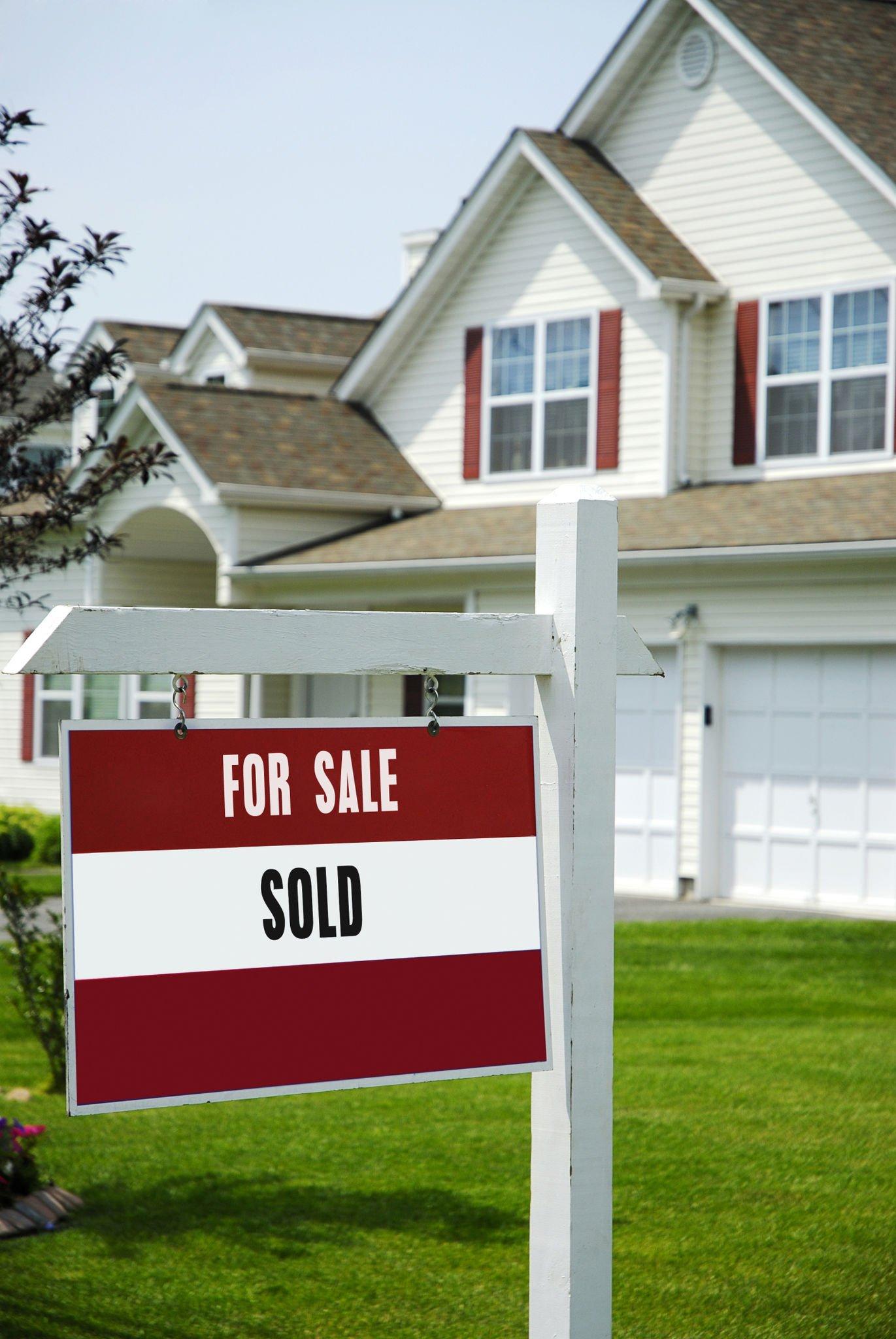 A for sale sold sign in front of a house