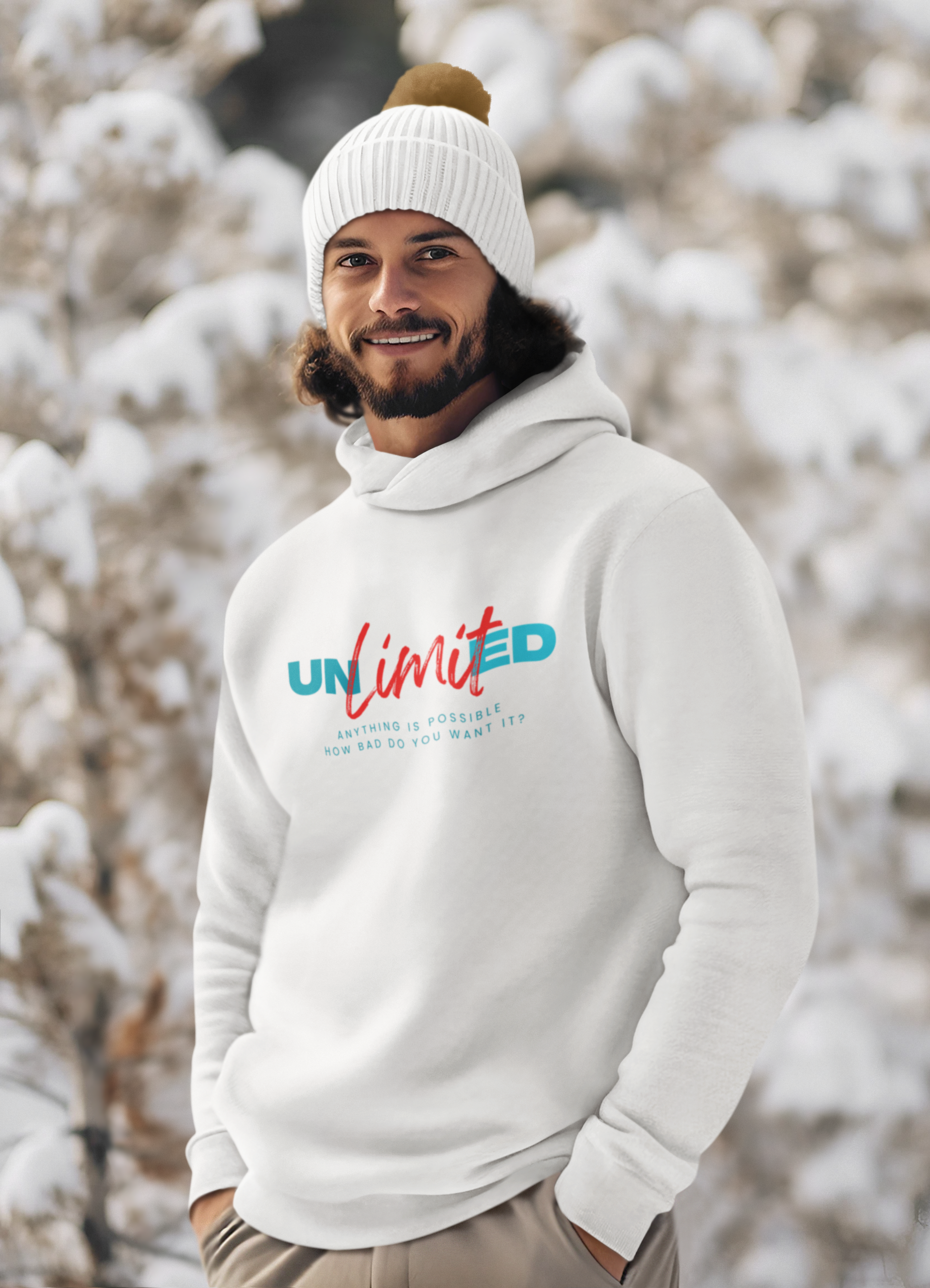 A man wearing a white hoodie and a white hat is standing in the snow.