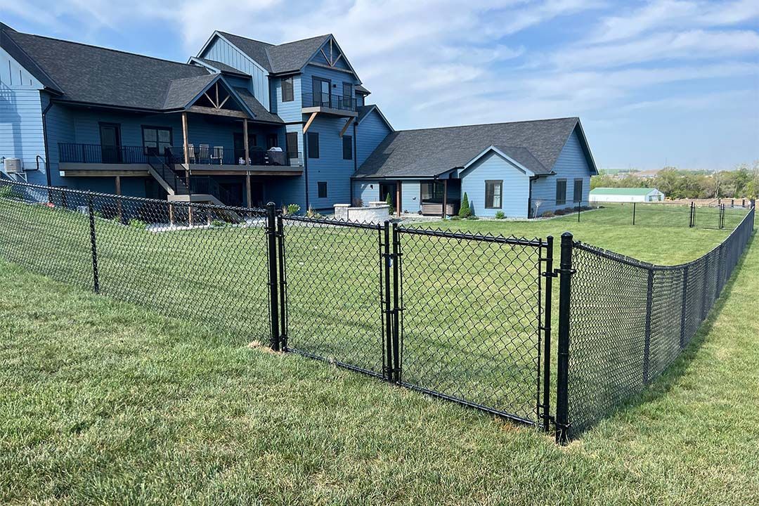 A large house with a chain link fence in front of it.
