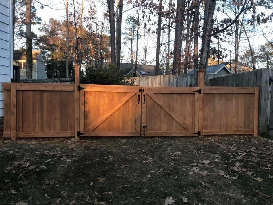 A wooden fence with a gate in the backyard