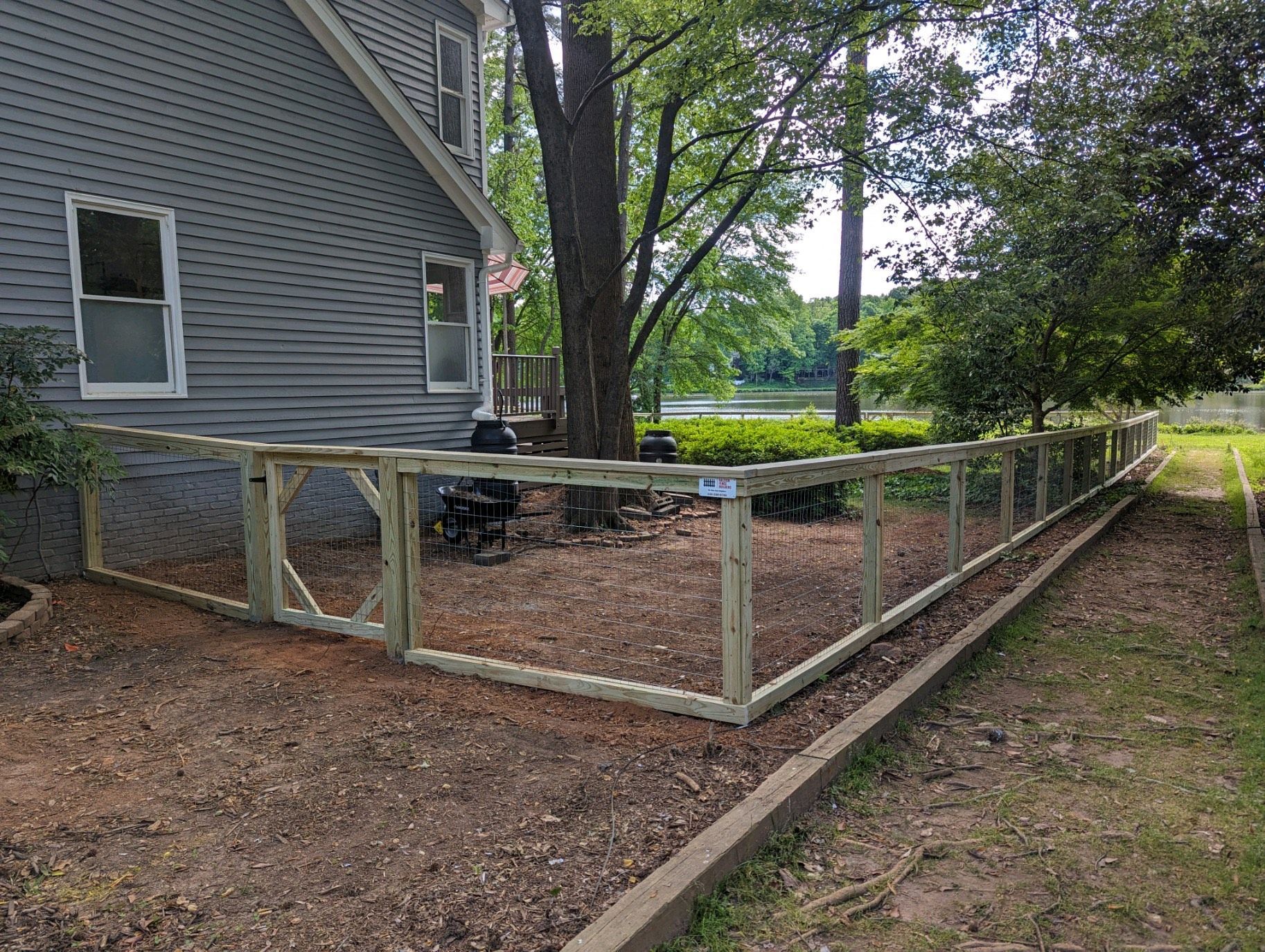 A wooden fence is being built in front of a house.