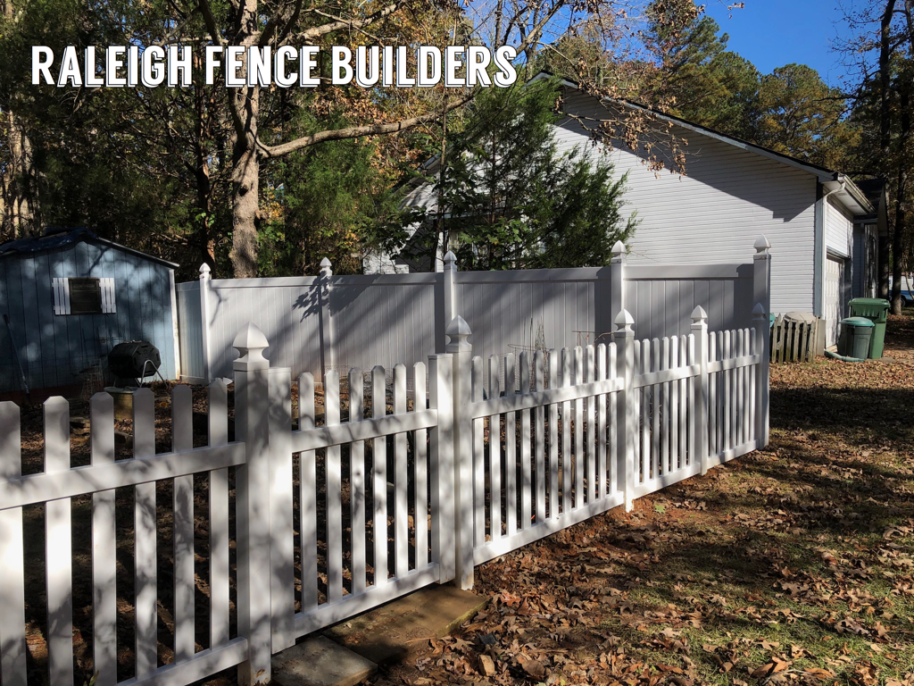 A white picket fence is in front of a house.