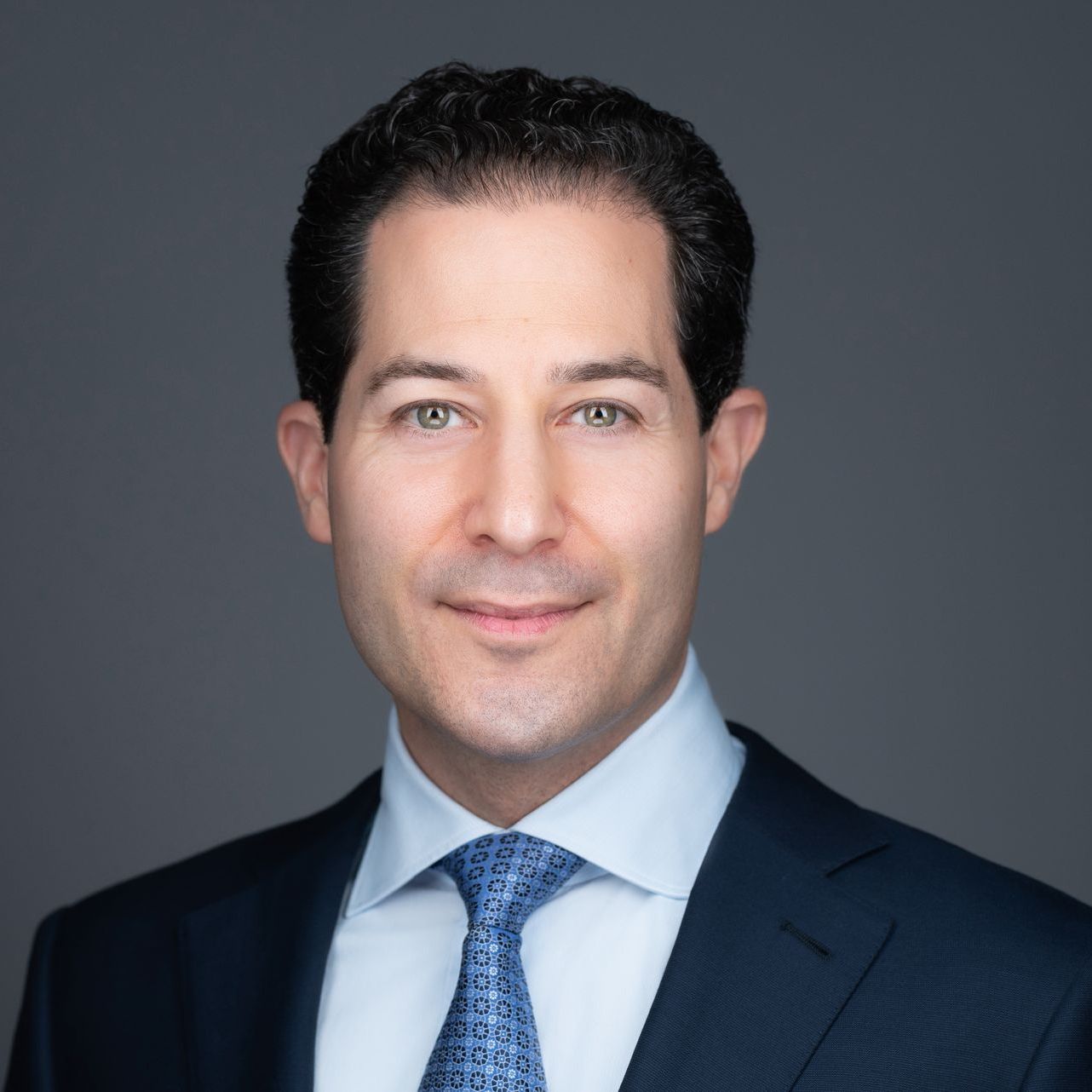 A man in a suit and tie is smiling for the camera.