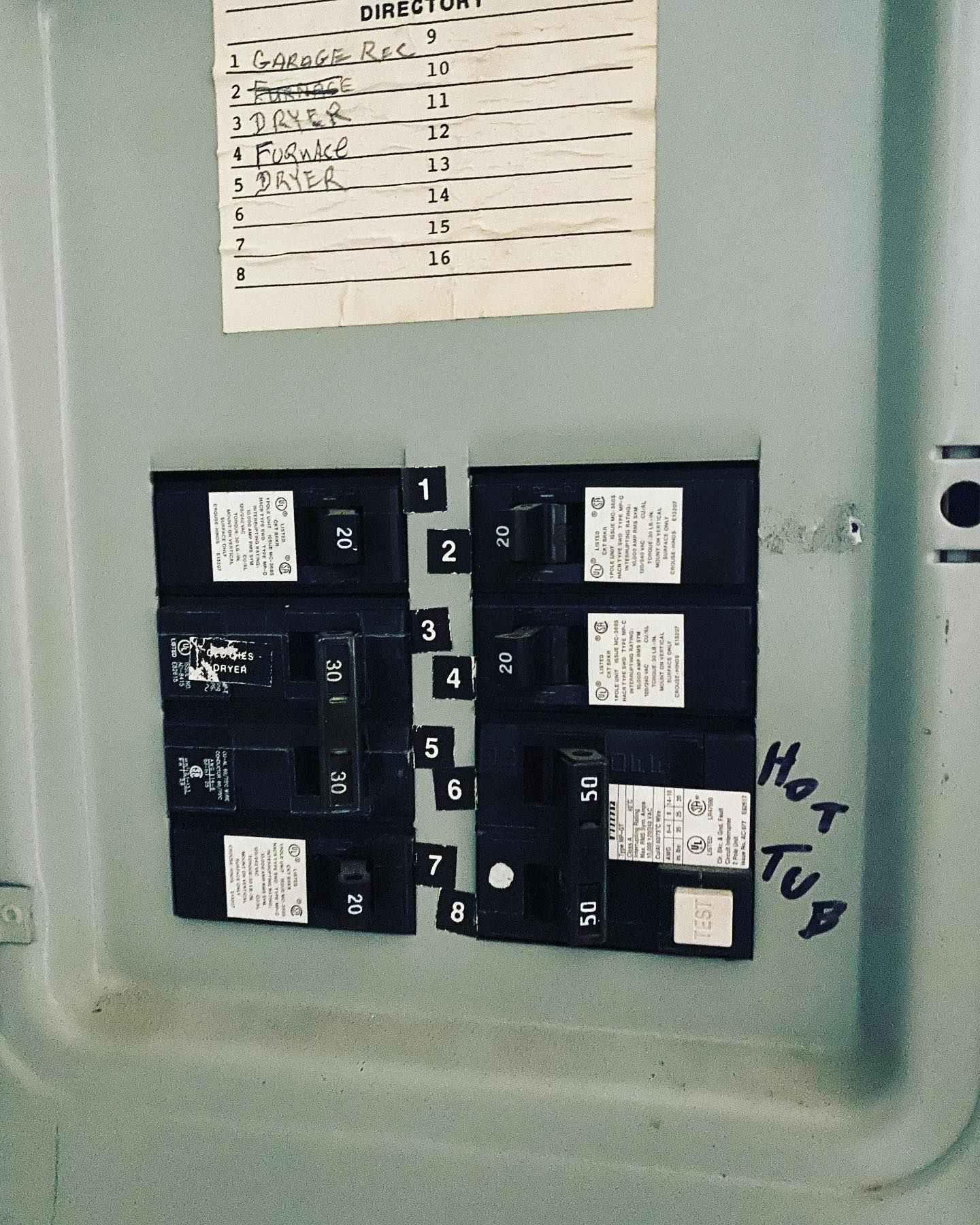 Electrical panel with labeled circuit breakers, including one for the hot tub.