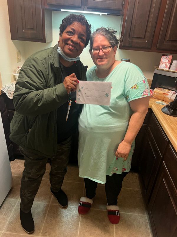 A man and a woman are posing for a picture in a kitchen.