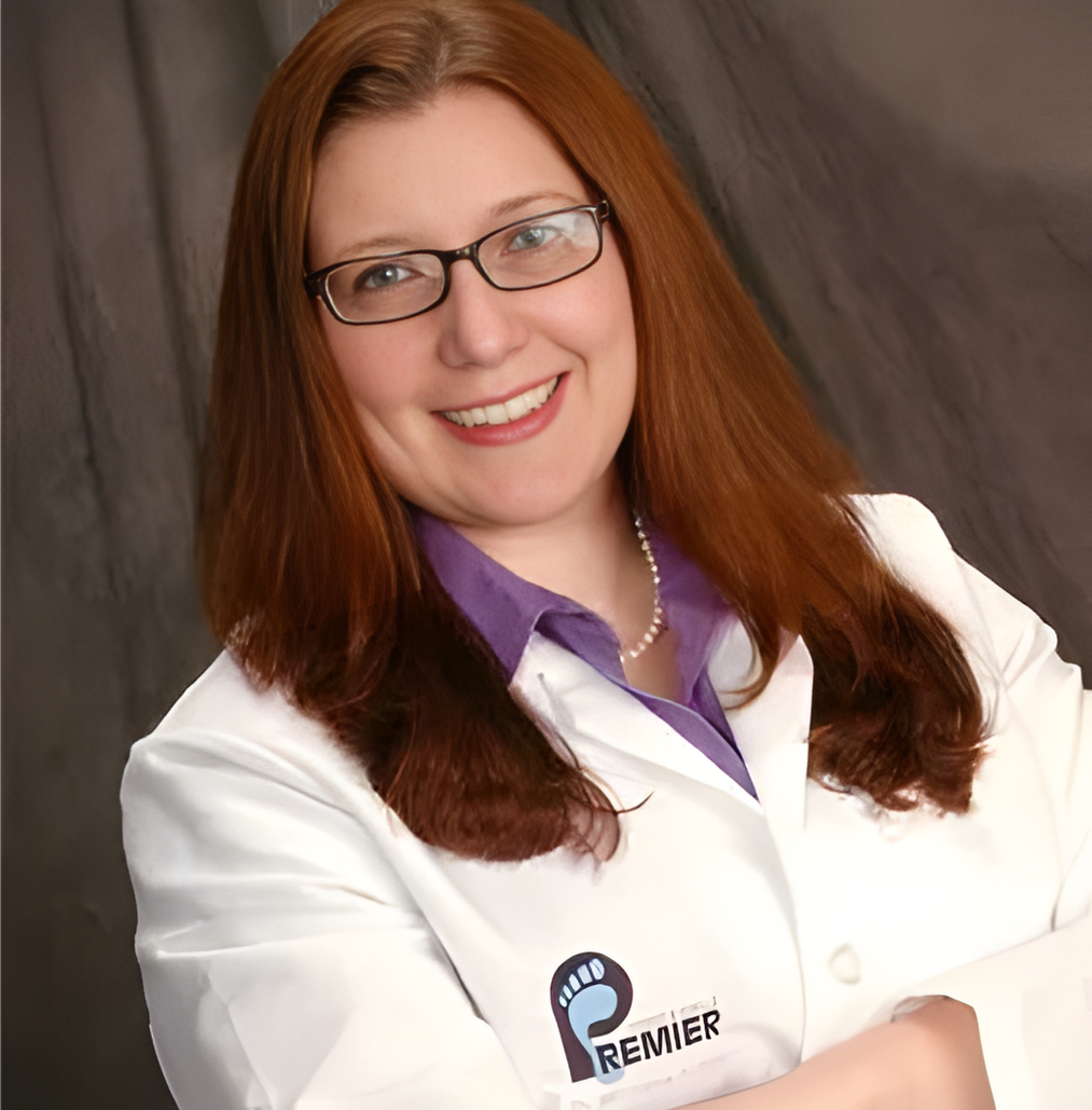 A smiling doctor in a lab coat with a stethoscope around his neck.