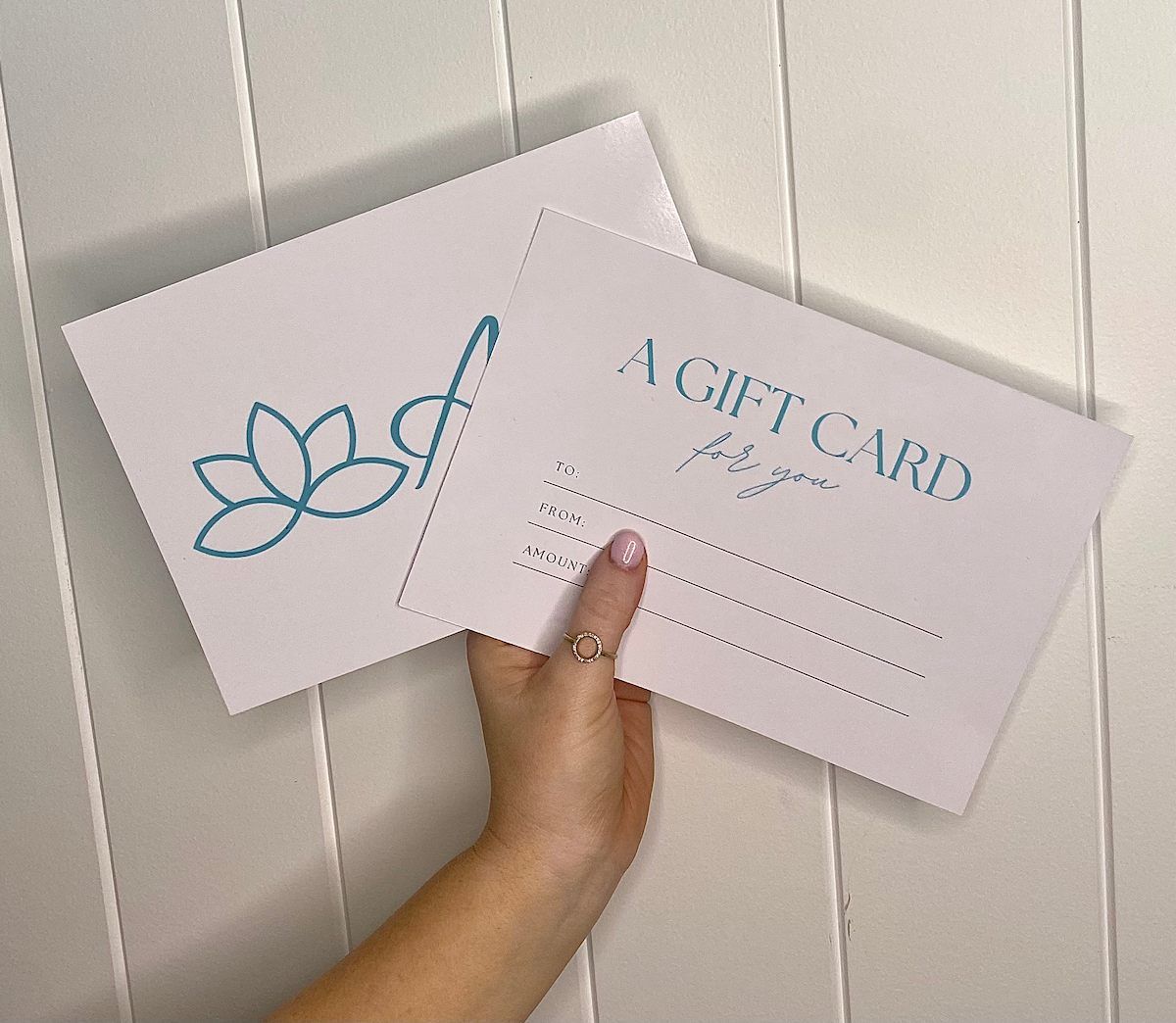 Hand Holding Two Pastel Gift Cards, One With One Labeled “A GIFT CARD.” — Aspire Beauty & Nails in Wagga Wagga, NSW