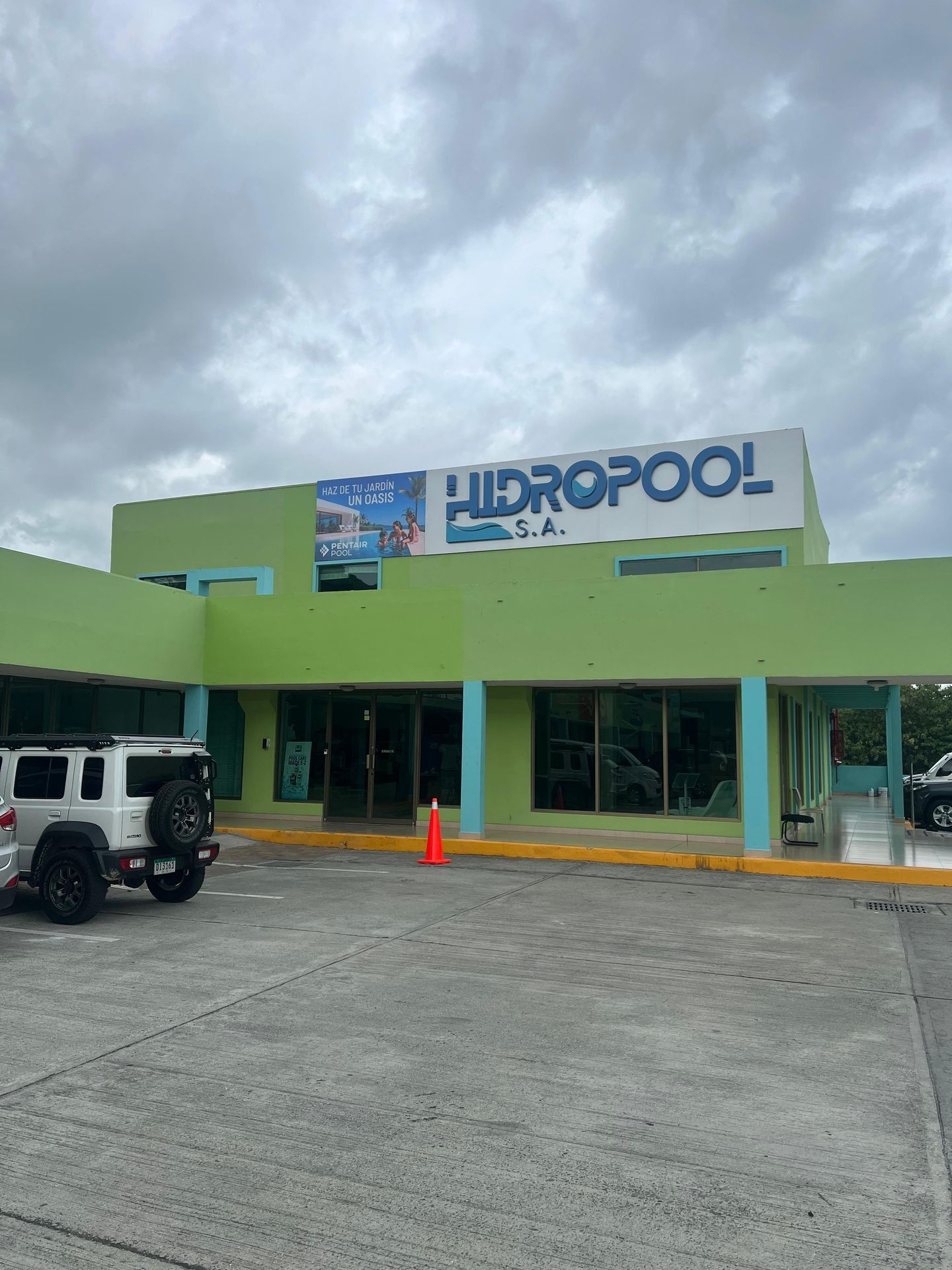 Local comercial con fachada verde y un gran letrero que dice "FIDROPOOL", con un SUV blanco estacionado afuera.