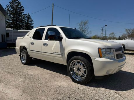 White SUV parked on a gravel lot under a clear blue sky